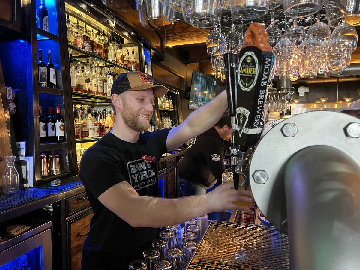Cozy Method Park City burger guide: a bartender pouring a local Utah draft beer at Boneyard Saloon in Park City