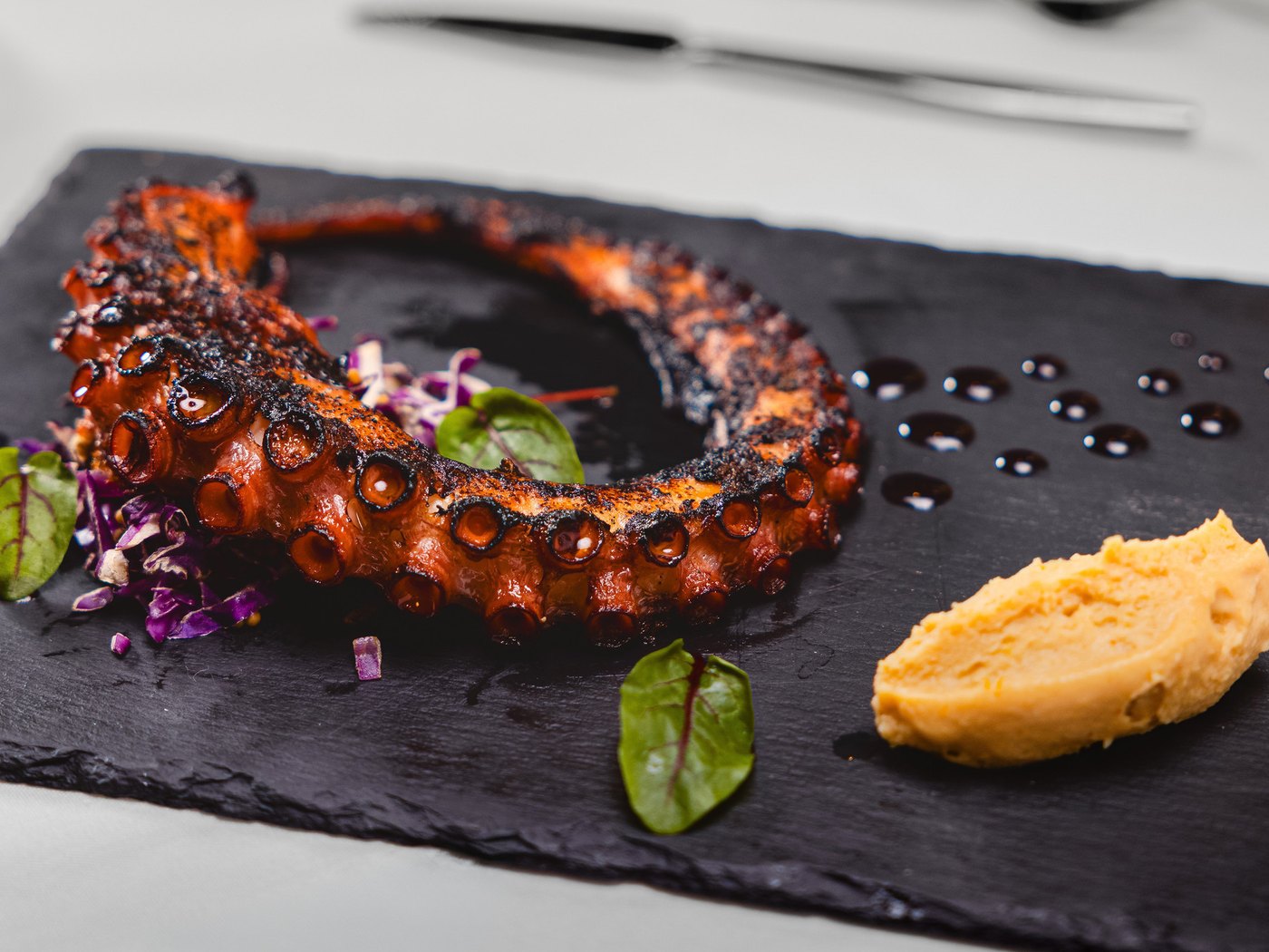 Cozy Method Park City steakhouse guide: grilled octopus starter plated on slate at Edge Steakhouse in Park City