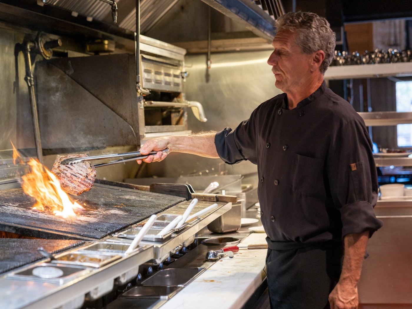 Cozy Method Park City steakhouse guide: the chef working the open hardwood charbroil at Grub Steak in Park City